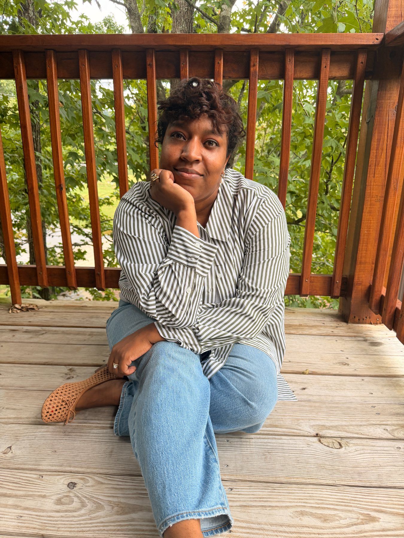 Ashley, sitting on a wooden deck